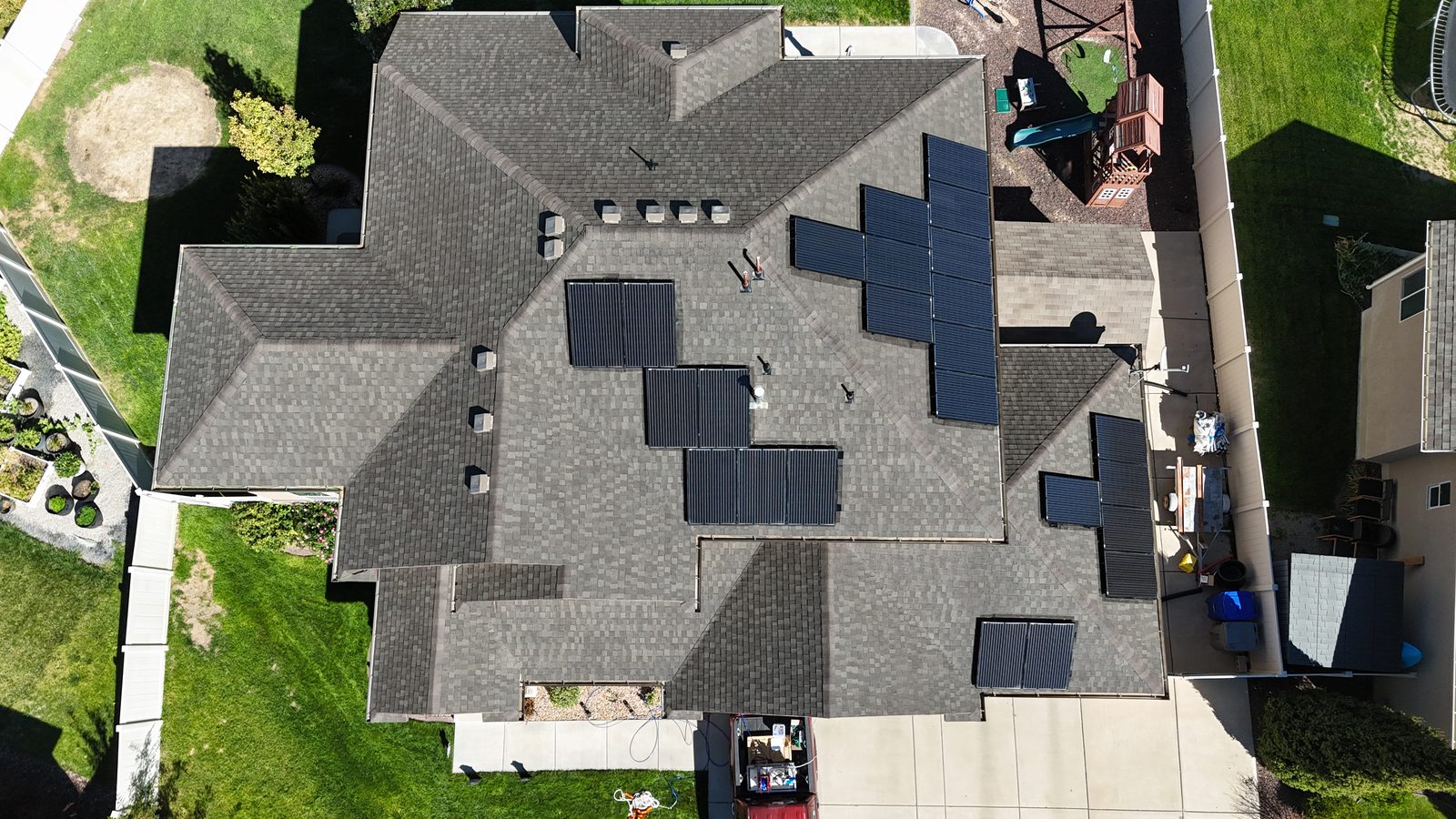 The same roof from directly overhead the next afternoon, the shingles noticeably darker after treatment.