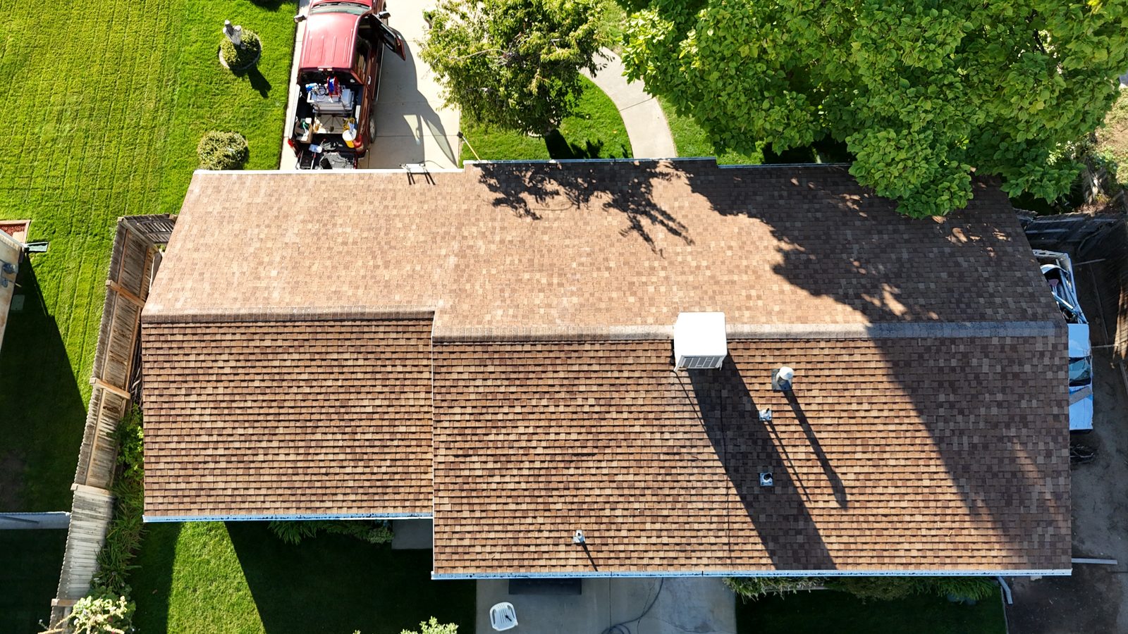 The same roof from overhead twenty minutes later, fully treated and visibly darker.